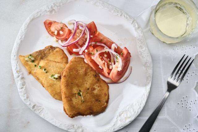 Pez espada empanado con tomates y cebolla roja